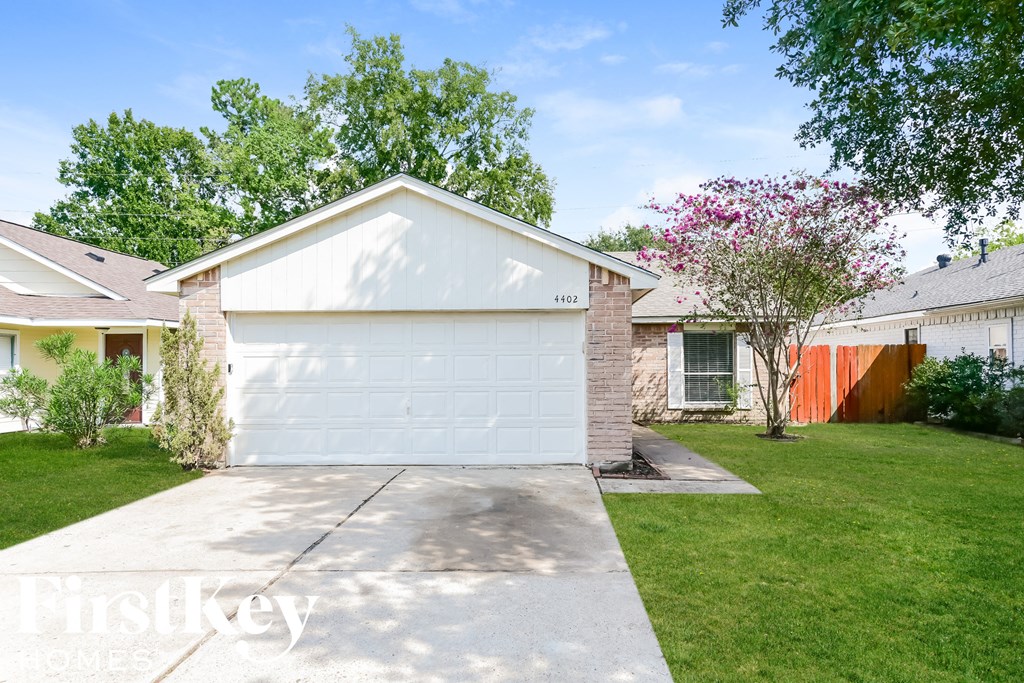 A white garage door is on the left side of a house.