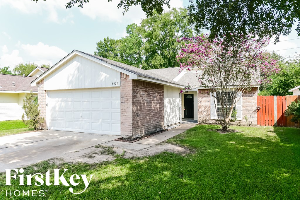A house with a white garage door and a brick chimney is for sale.