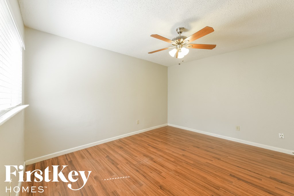 A room with wooden floors and a ceiling fan.