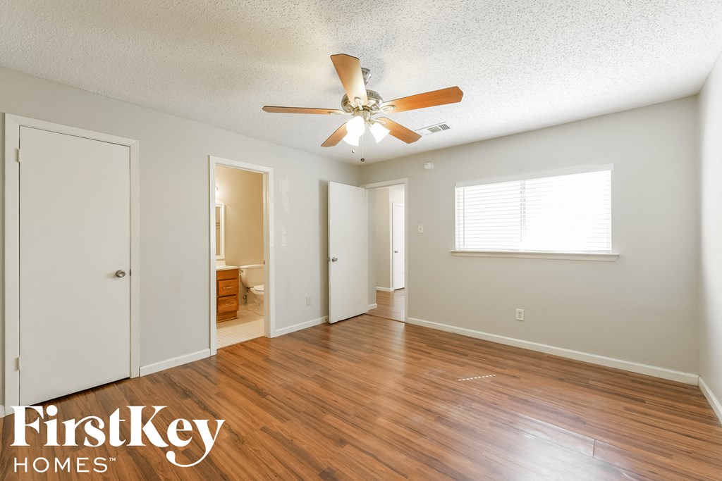 A room with wooden floors and a ceiling fan.
