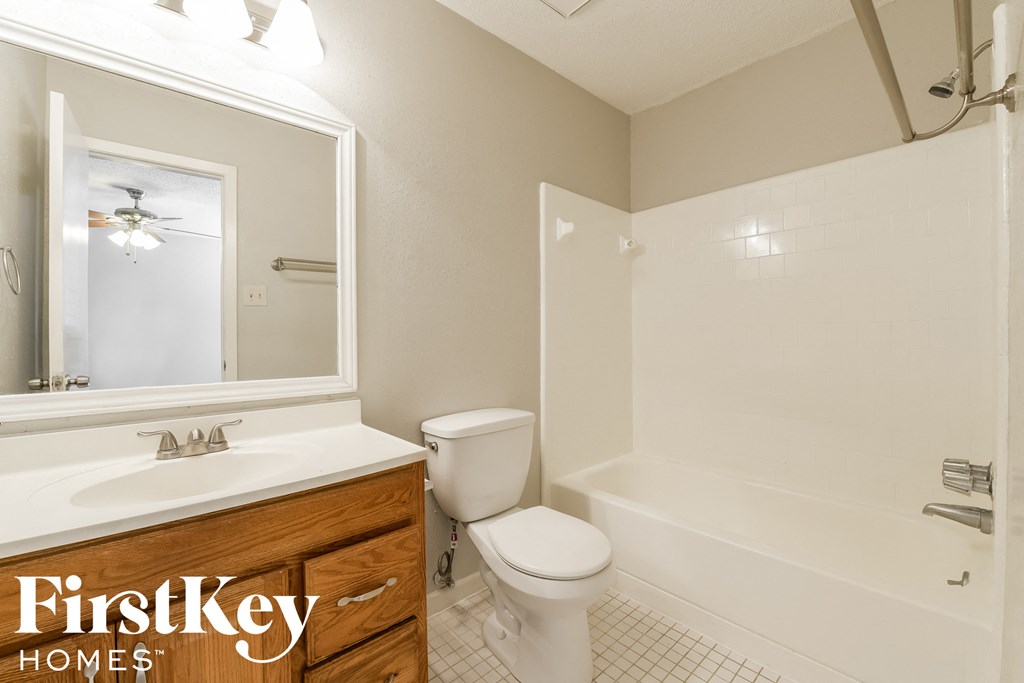 A bathroom with a toilet, sink, and bathtub.