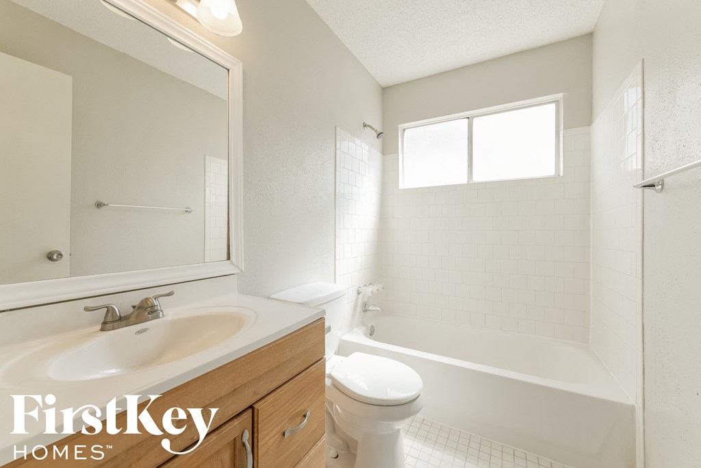 A white bathroom with a FirstKey Homes logo.