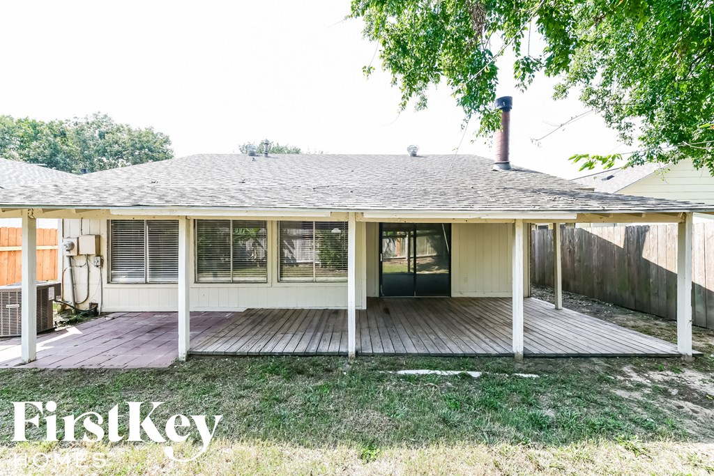 A house with a porch and a tree in front of it.
