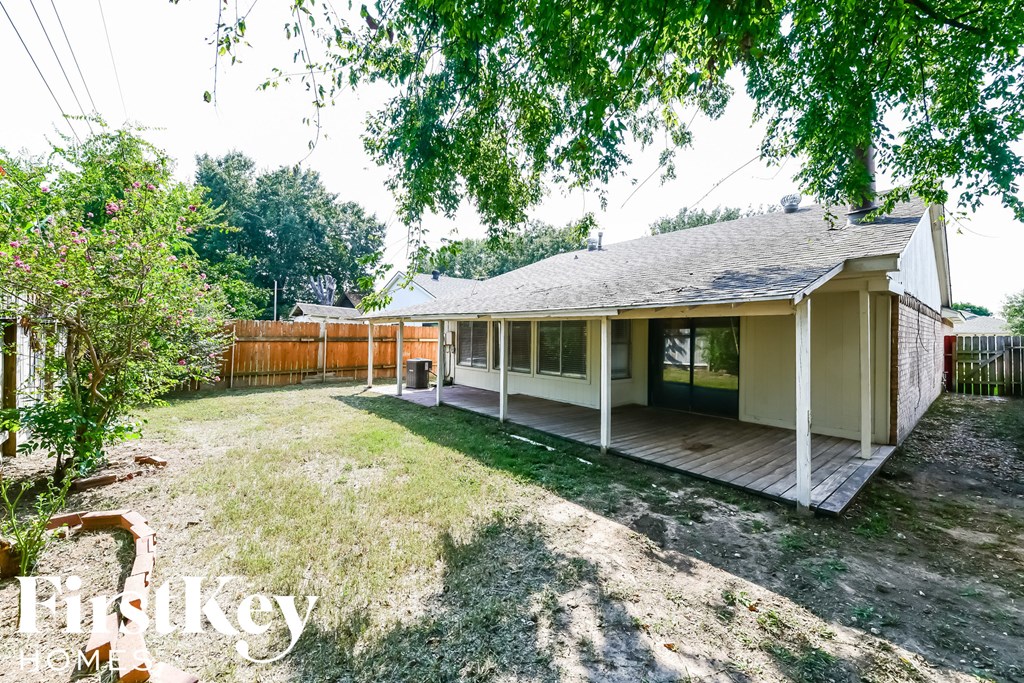 A house with a porch and a fence in the yard.