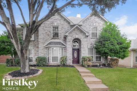 a brick house with a tree in front of it