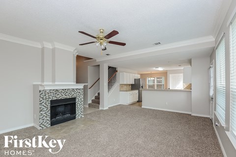 a living room with a fireplace and a ceiling fan