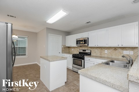 a kitchen with white cabinets and stainless steel appliances and a sink