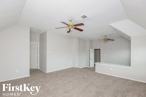 a bedroom with a ceiling fan and a carpeted floor