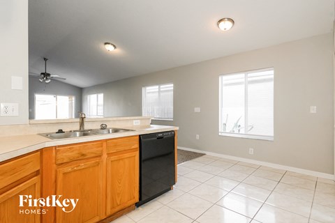A kitchen with wooden cabinets and a black dishwasher.