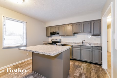 a kitchen with granite counter tops and gray cabinets