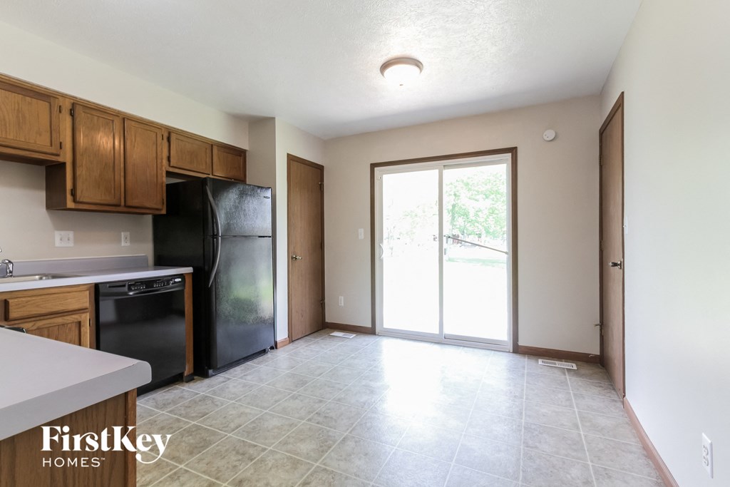 an empty kitchen with black appliances and wood cabinets
