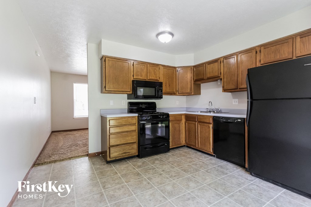 a kitchen with black appliances and wooden cabinets