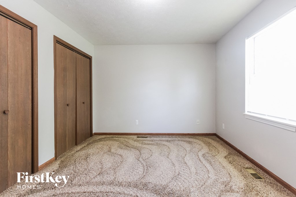 a bedroom with a carpeted floor and white walls