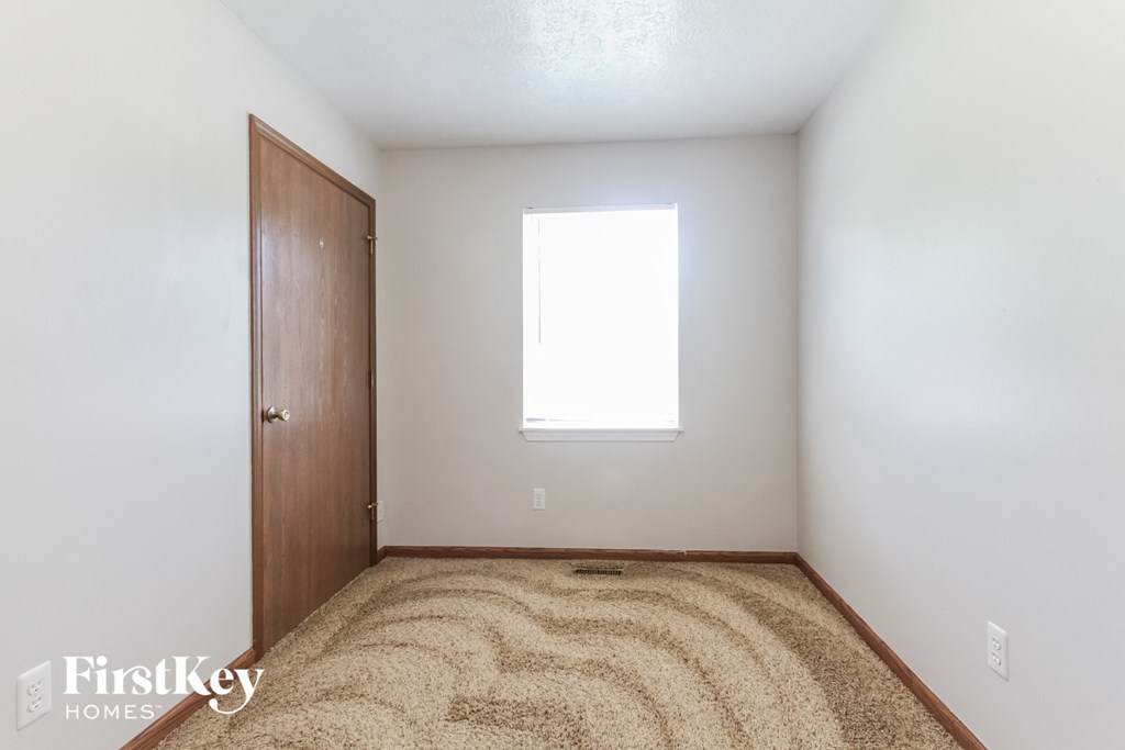 an empty room with a door and a window