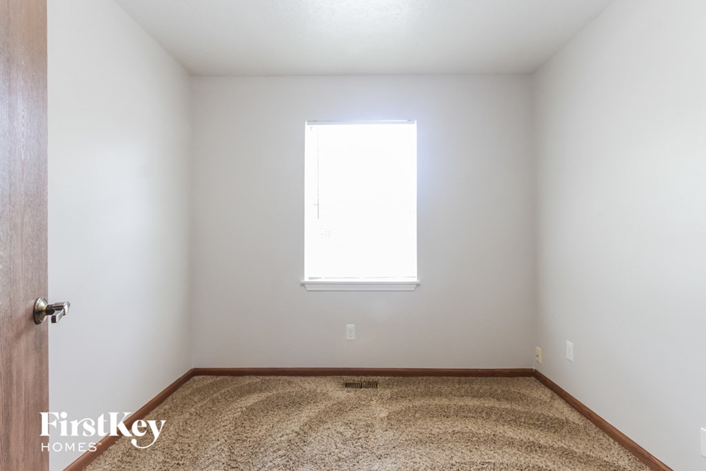 a white room with a window and a carpet