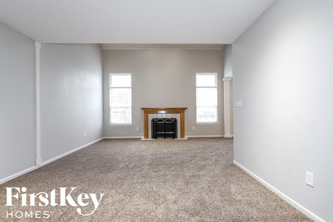a living room with carpet and a fireplace