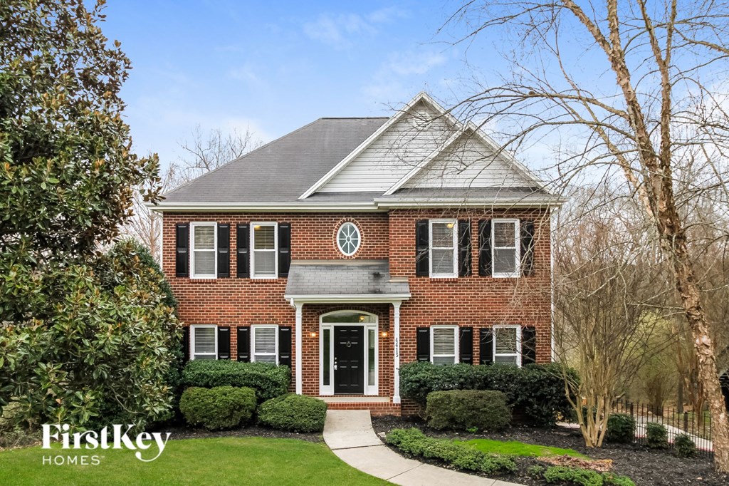 a red brick home with white shutters and a black door