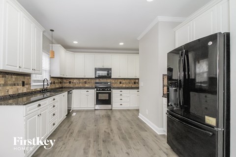 a renovated kitchen with white cabinets and black appliances