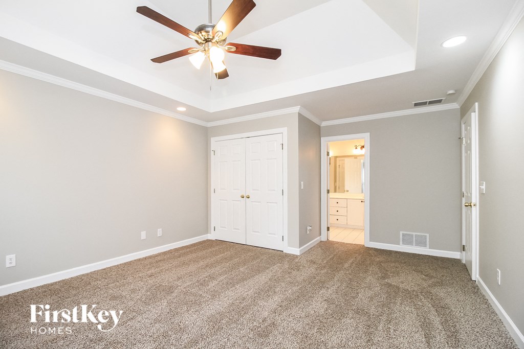 a living room with carpet and a ceiling fan