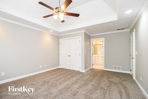 a living room with carpet and a ceiling fan