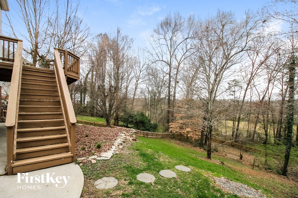 stairs to the deck of a cabin with trees and a river