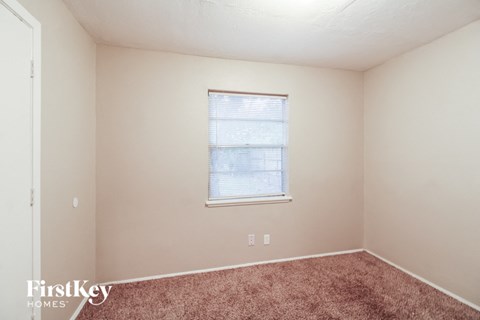 a bedroom with carpet and a window