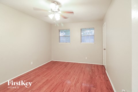 a spacious living room with wood flooring and a ceiling fan