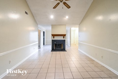 an empty living room with a fireplace and white walls