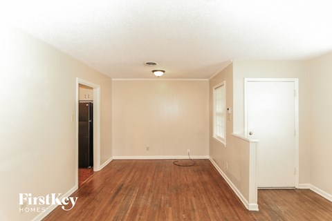 a living room with a hard wood floor and white walls