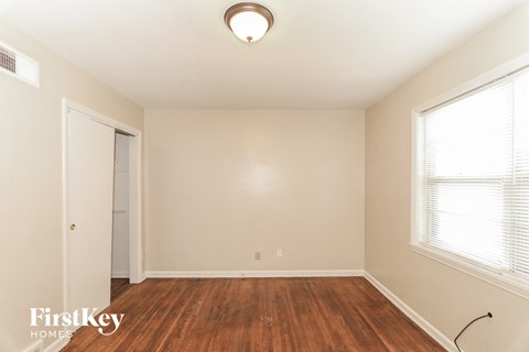 a bedroom with wood flooring and a door to a closet