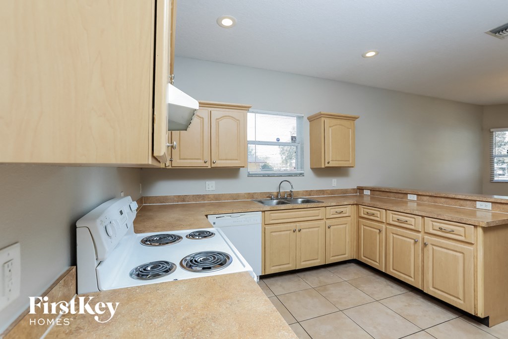 a kitchen with wooden cabinets and a stove top oven and a sink