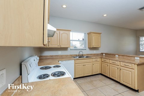 a kitchen with wooden cabinets and a stove top oven and a sink