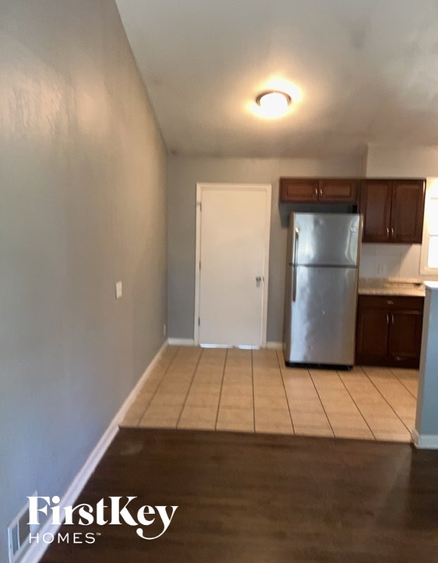 A kitchen with a refrigerator and cabinets.