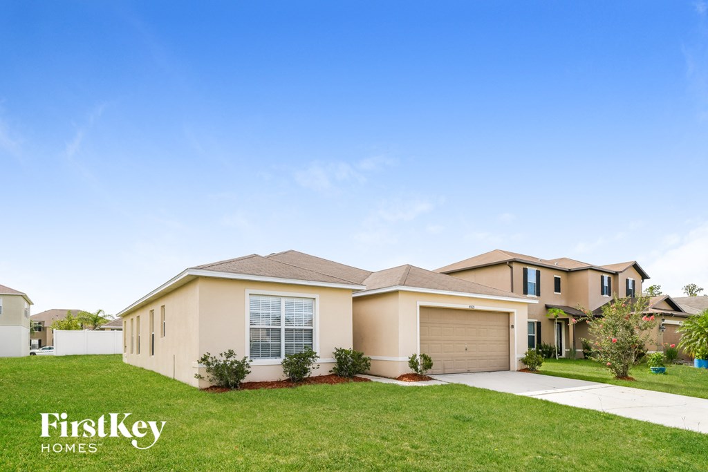 a beige house with a lawn in front of it