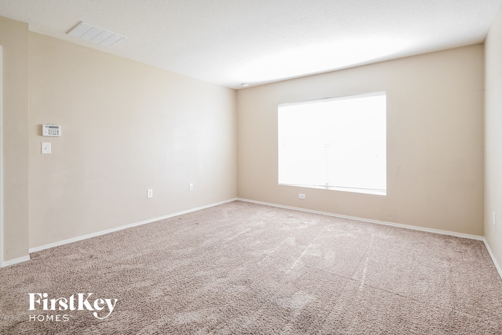 a empty room with carpet and a window