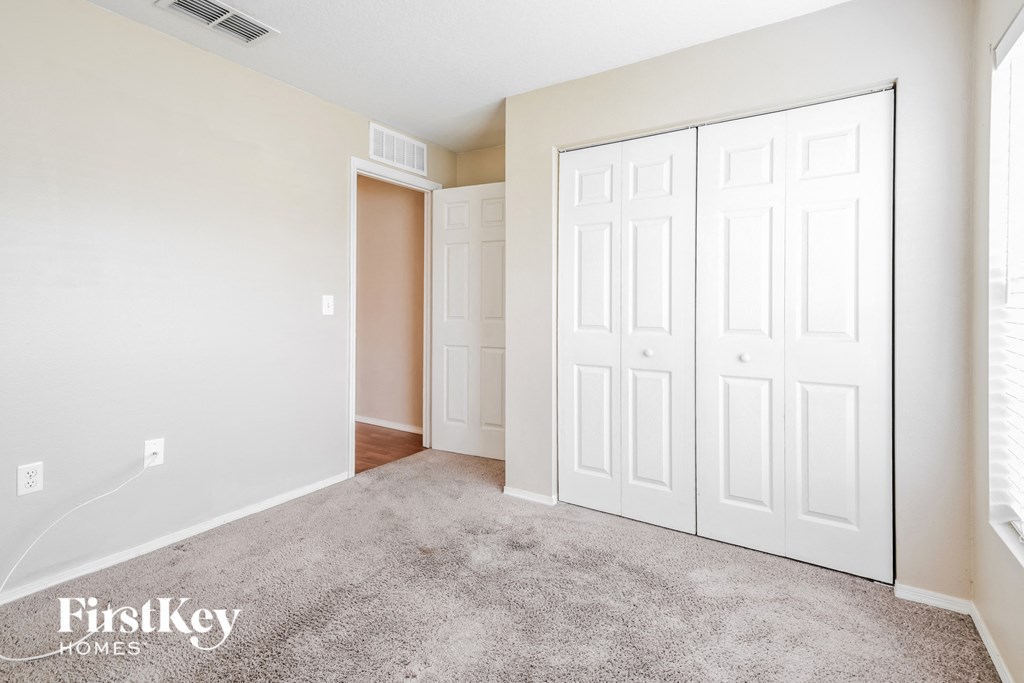a bedroom with two closets and a carpeted floor