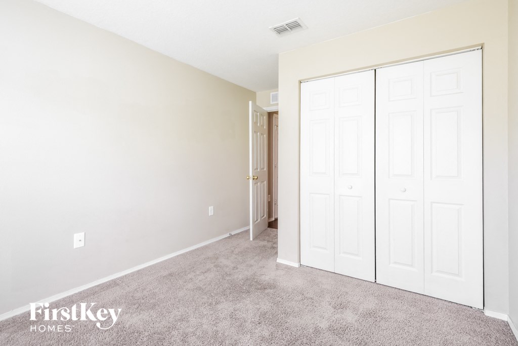a bedroom with two closets and a carpeted floor
