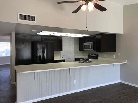 A kitchen with black cabinets and a white countertop.