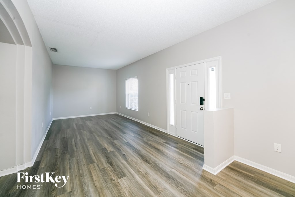 A room with wooden flooring and a white door.