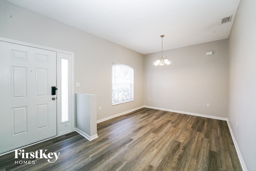 A room with wooden flooring and a white door.