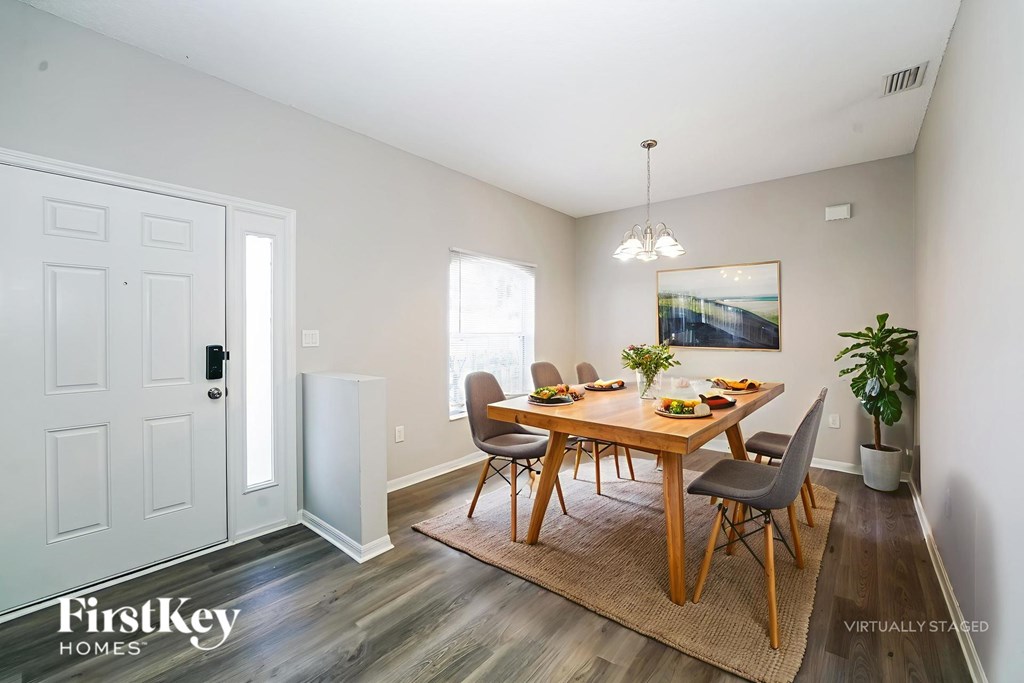 A dining room with a wooden table and chairs.