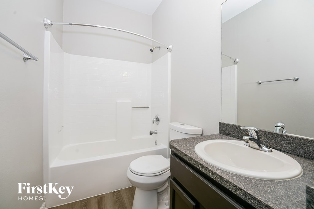 A bathroom with a white toilet, a white sink, and a white bathtub.