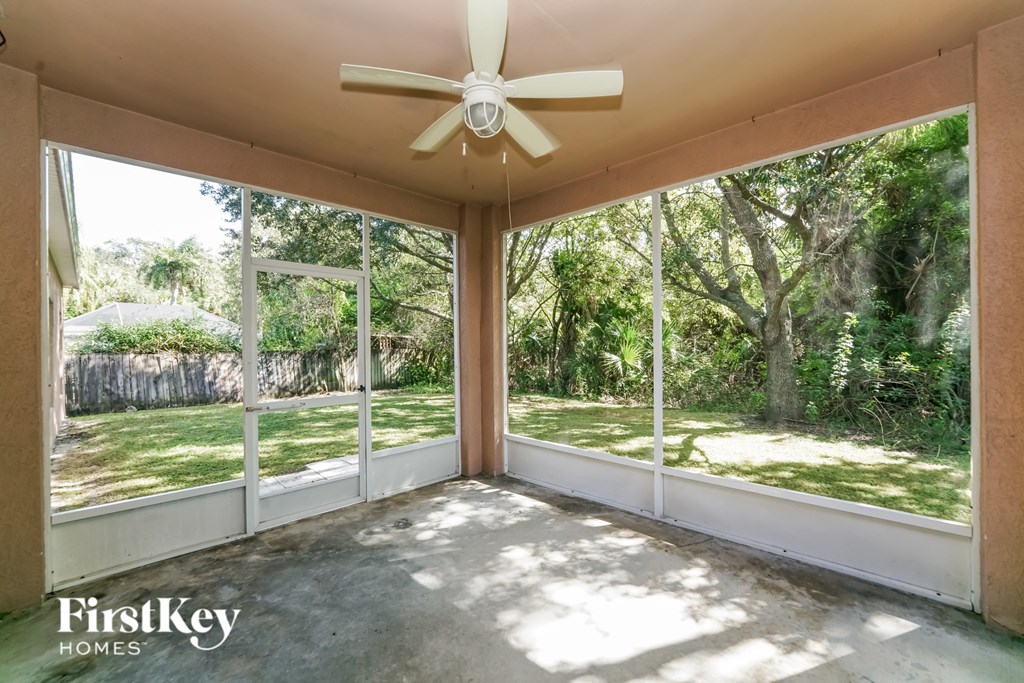 A sunny patio with a ceiling fan and sliding glass doors.