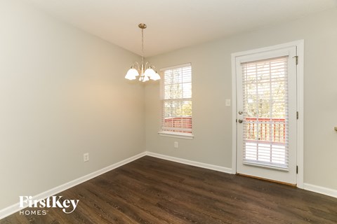 a living room with wood flooring and a door to a balcony