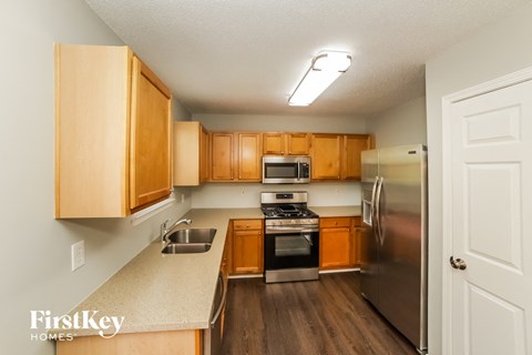 an empty kitchen with wooden cabinets and stainless steel appliances