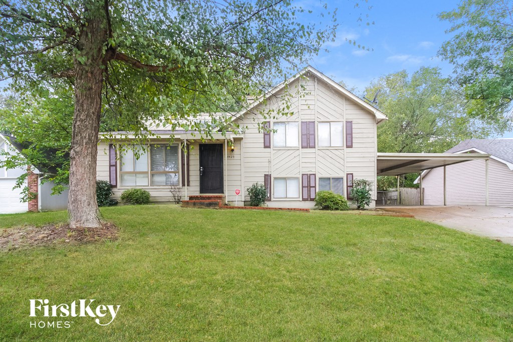 a white house with a yard and a tree