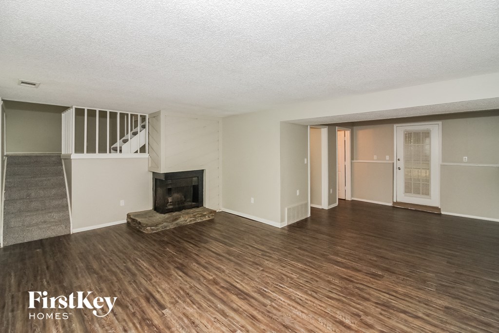 a living room with a wood floor and a fireplace