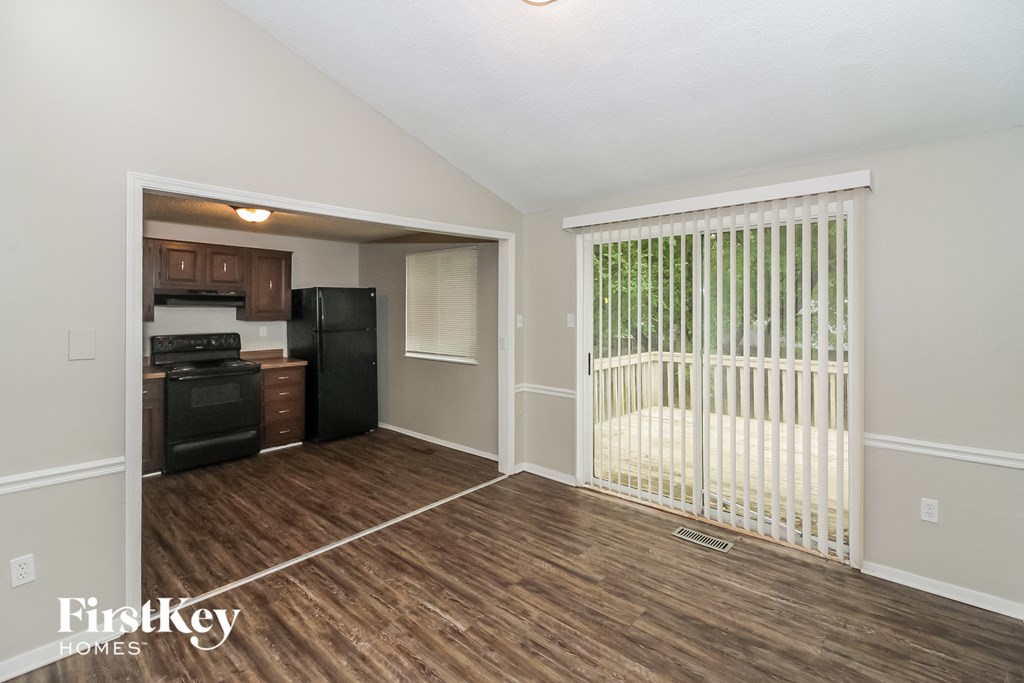 the living room of an apartment with a wooden floor and a white gate