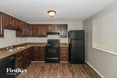a kitchen with black appliances and wooden cabinets