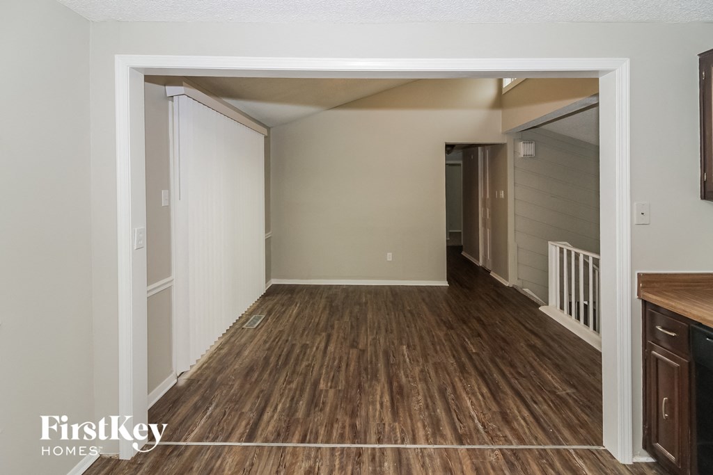 the living room and dining room of an apartment with wood flooring